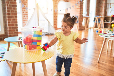 美丽的幼儿在幼稚园与建筑构件玩具一图片