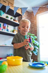 幼稚的天主教儿童在幼儿园玩具厨房图片