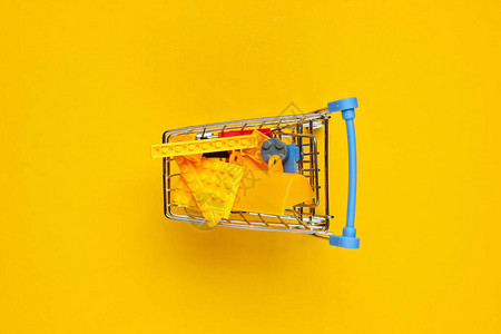 带有黄色背景玩具砖的小型购物小车儿童购物的概念顶级图片