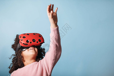 非裔美国女孩玩虚拟现实眼镜游戏电脑游戏蓝背景情绪等东图片