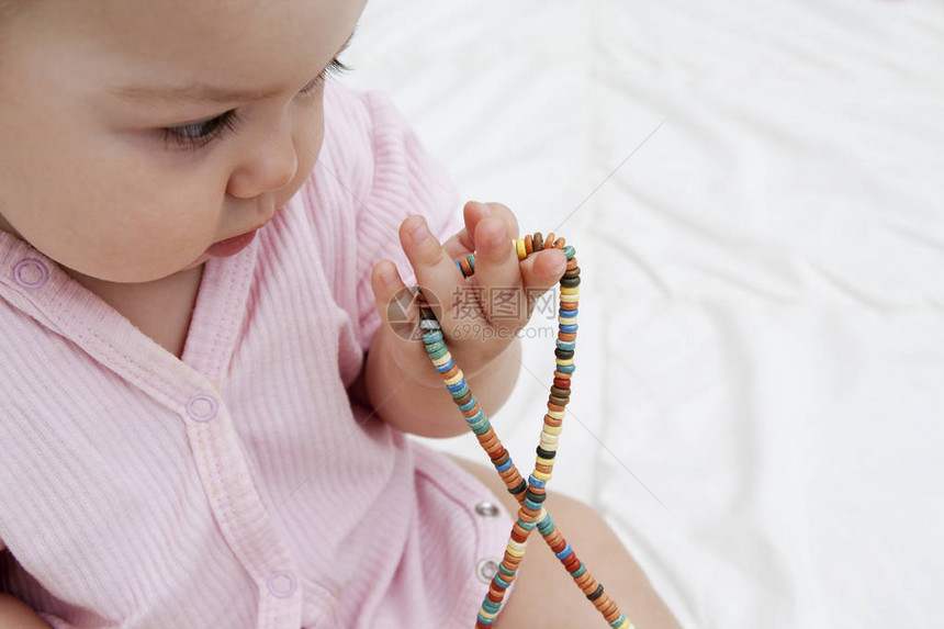 婴儿手中的有色珠子培养儿童的精细运图片