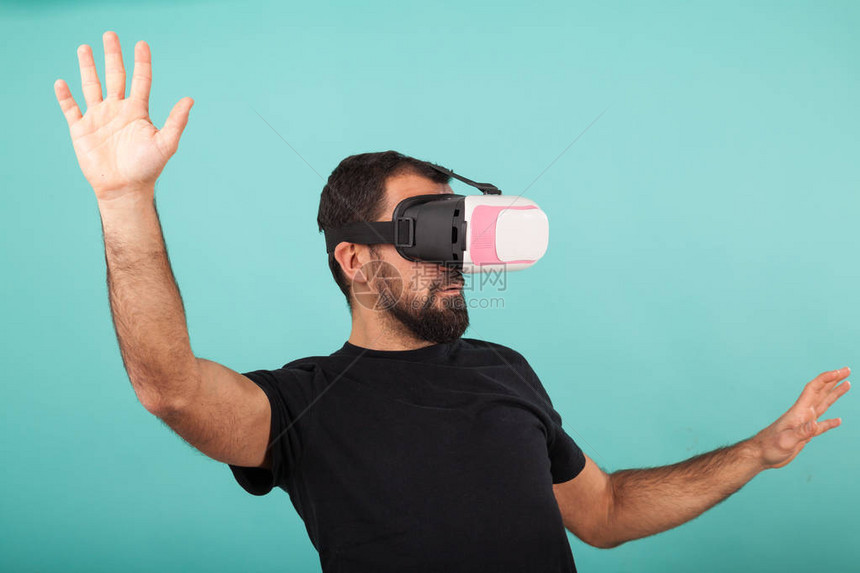 有胡子的人使用虚拟现实眼镜护目镜Vr耳机的家伙正在看交互式屏幕在设备上玩手机图片