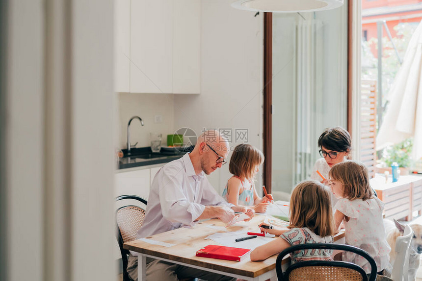美丽的天主教家庭在家里坐在桌椅绘画游戏家庭学校教育图片