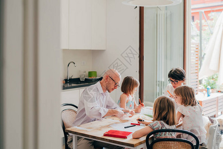 美丽的天主教家庭在家里坐在桌椅绘画游戏家庭学校教育图片