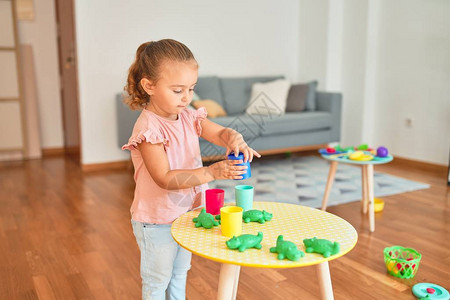 在幼儿园玩塑料青蛙玩具的美丽金发小图片