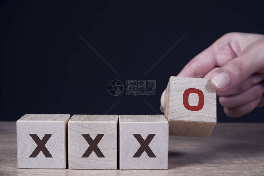 男手将O符号打印屏幕放在木制立方体和X木制立方体上正确和不正图片