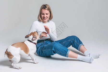 训犬师一个年轻女孩在演播室里带着白色背景和她有趣的背景