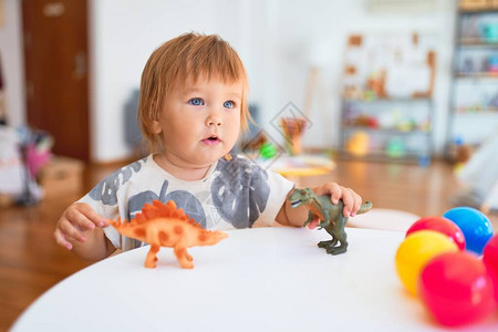 幼稚园很多玩具周围玩恐龙的可爱小孩儿图片
