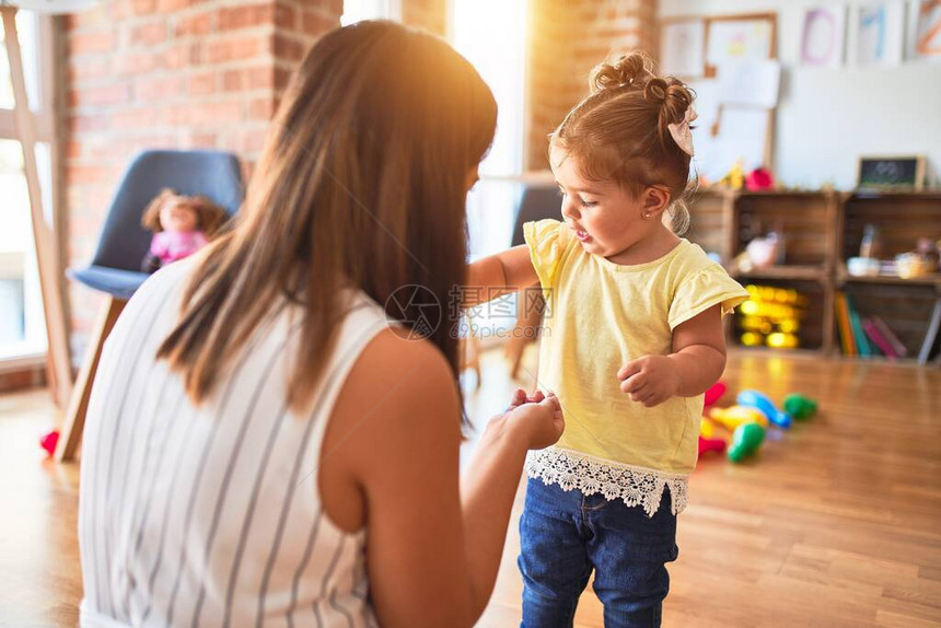 年轻漂亮的老师和幼儿在幼儿园图片