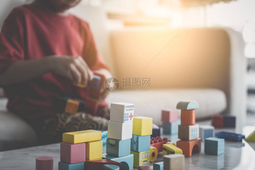 亚洲男孩堆叠玩具街区儿童在客厅桌边玩图片