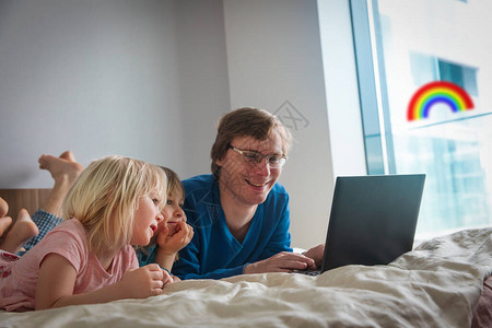 父亲带着孩子在家看电脑图片