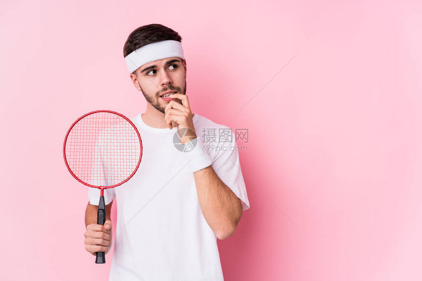 玩羽毛球的年轻天主教男子孤立地思考着一些寻找复制空间的东西图片
