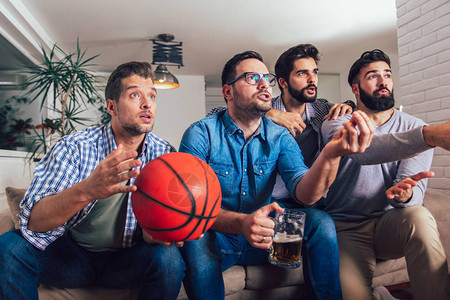 快乐的朋友或篮球迷在电视上观看篮球比赛高清图片