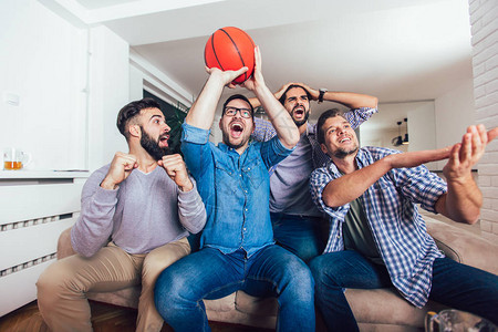 快乐的朋友或篮球迷在电视上观看篮球比赛图片