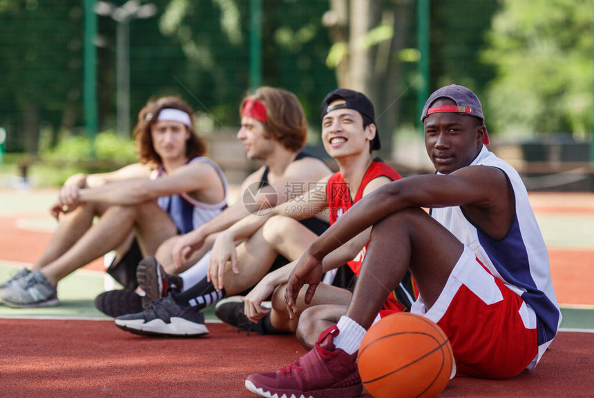 多种族篮球运动员队在户外法庭自由空间的游戏结束后图片