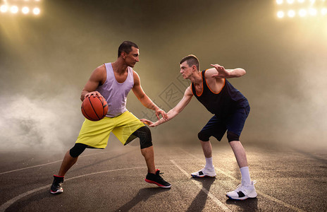 两名篮球运动员在球场上打球图片