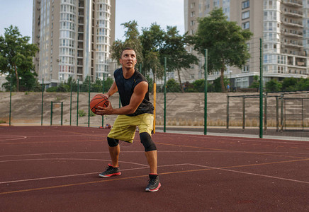 篮球运动员准备在室外球场上投篮运动服的男运动员在街图片