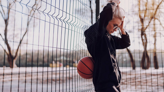 年轻美女在野外站着休息打篮球后休图片
