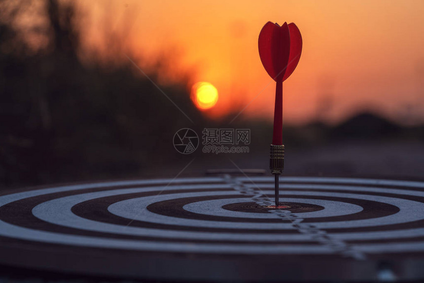 在日落背景上锁定红飞镖箭击中目标中心电灯板业务目标与焦点图片