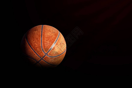 体育概念黑色背景上的旧篮球图片