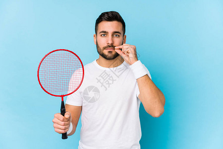 玩羽毛球的英俊小伙子孤立地用手指着嘴图片