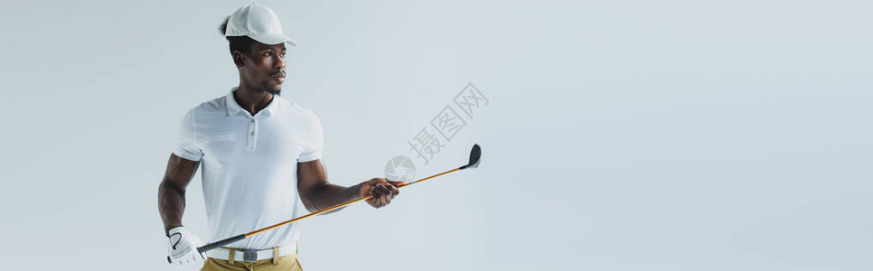 英俊的非裔美国运动员拿着高尔夫俱乐部在灰色地带图片