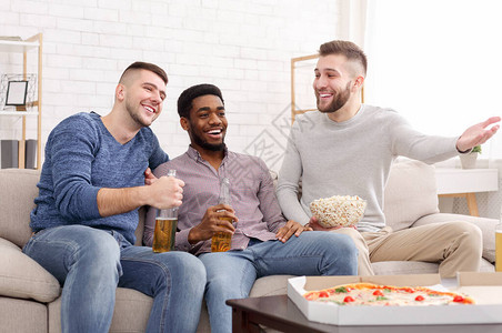 三个足球迷在家里看电视比赛带图片