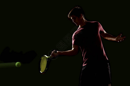 年轻的网球运动员准备打黑背景的背景图片