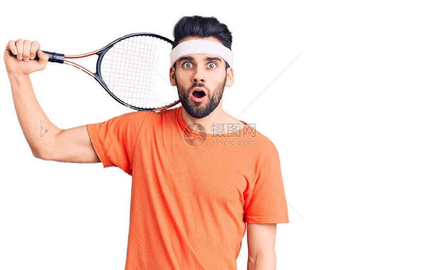 留着胡子打网球的年轻帅哥拿着球拍吓得张开嘴惊讶图片