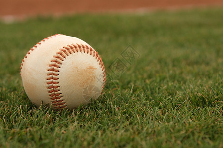 外野草地上的棒球背景图片