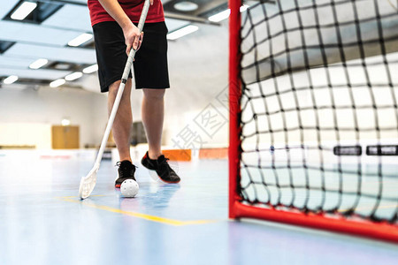 地板球运动员在球场上训练地板曲棍球概念在竞技场上用棍子和球奔跑的图片