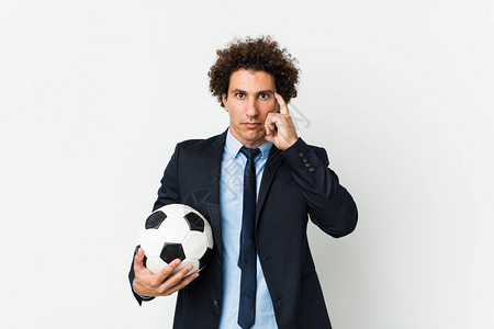 足球教练拿着球用手指着他的思考专图片