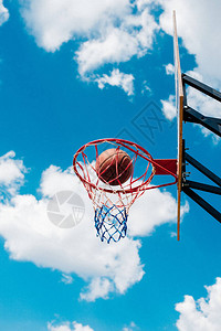 球在蓝天的篮球环中球飞入环状云层图片