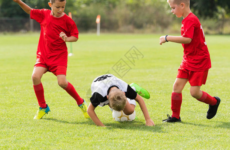 男孩们在球场上踢足球图片