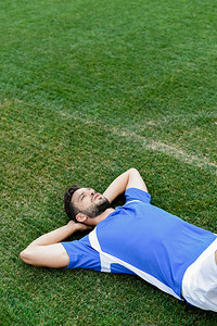蓝白制服的职业足球运动员躺在体育图片