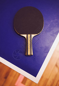 蓝桌角上的网球拍乒乓球比赛图片