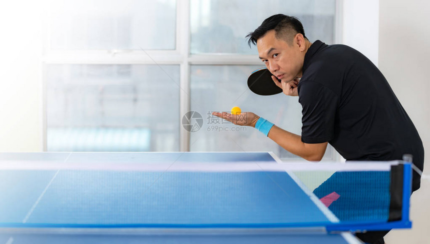 乒乓球桌男子在体育厅打网球图片