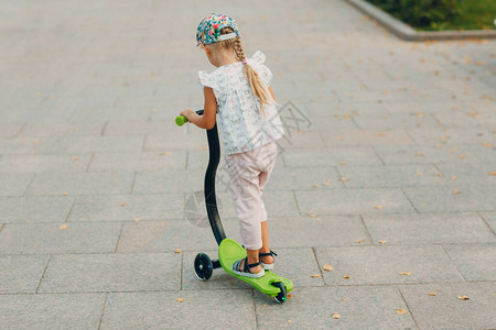 在城市街道上骑摩托车的小女孩图片