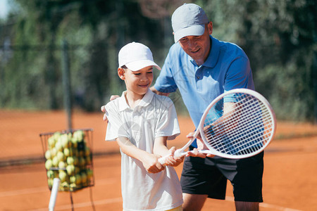 笑网球教练男孩如何玩网球网球在图片