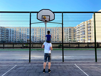 年轻的白种人父子在院子里打篮球暑假周末儿童休闲概念图片