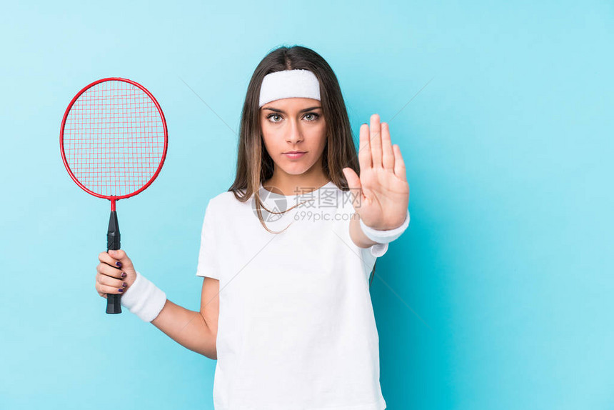 玩羽毛球的年轻caucasicic女人孤立地站在伸展的手外显示停图片