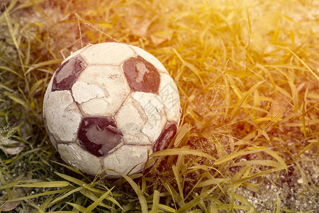 旧的足球或足球在草地上阳光充图片