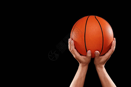 深色背景中带球的篮球运动员的手背景图片