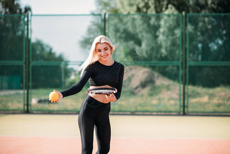 年轻漂亮的女人在球场上打网球健康的图片