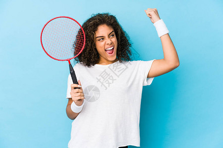 年轻非洲女玩羽毛球在胜利后举起拳头图片