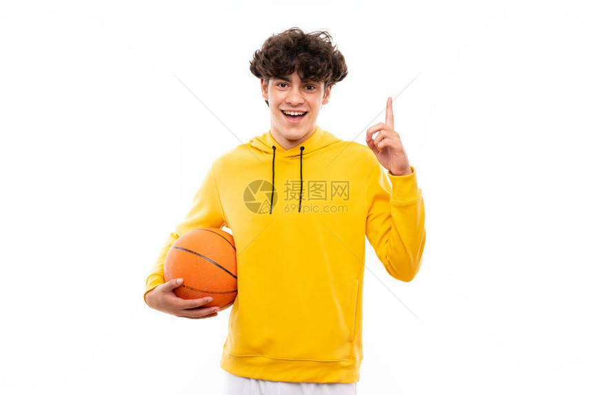 年轻篮球运动员在孤立的白墙上指图片