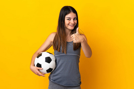 年轻女足球运动员在黄色背景下被孤立图片