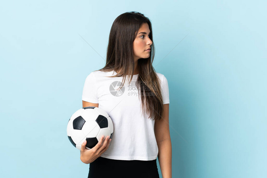 年轻足球运动员brazilian女孩孤立在蓝背景的蓝色图片