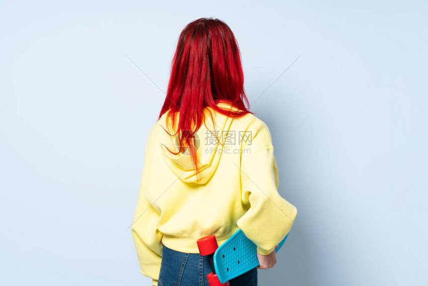 年轻红发女郎蓝背景和后方滑冰图片