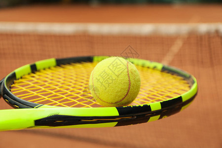 有网球的网球拍反对红土场背景